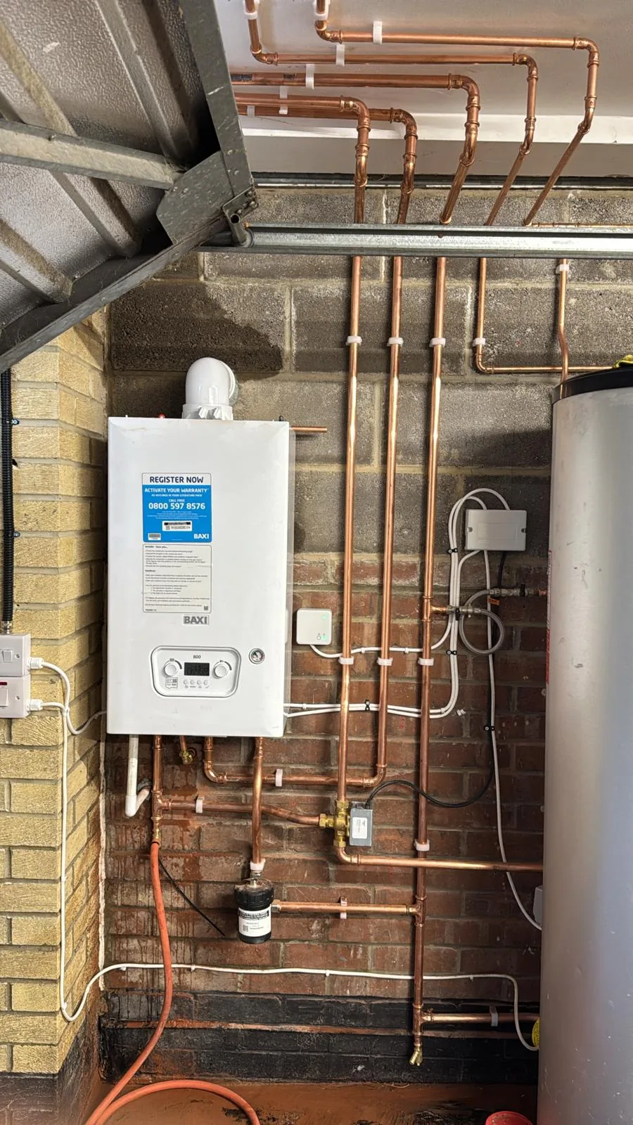 Wall hung boiler with new copper pipework run neatly up a brick wall