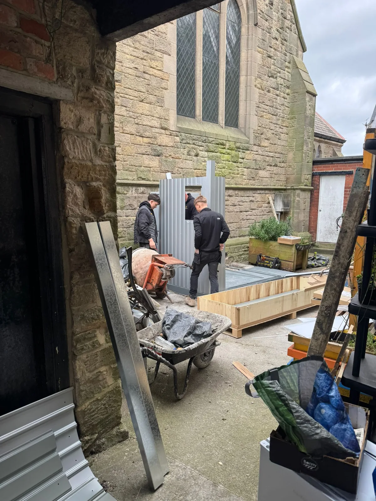 Arnotts engineers working outside a stone church during a heating installation