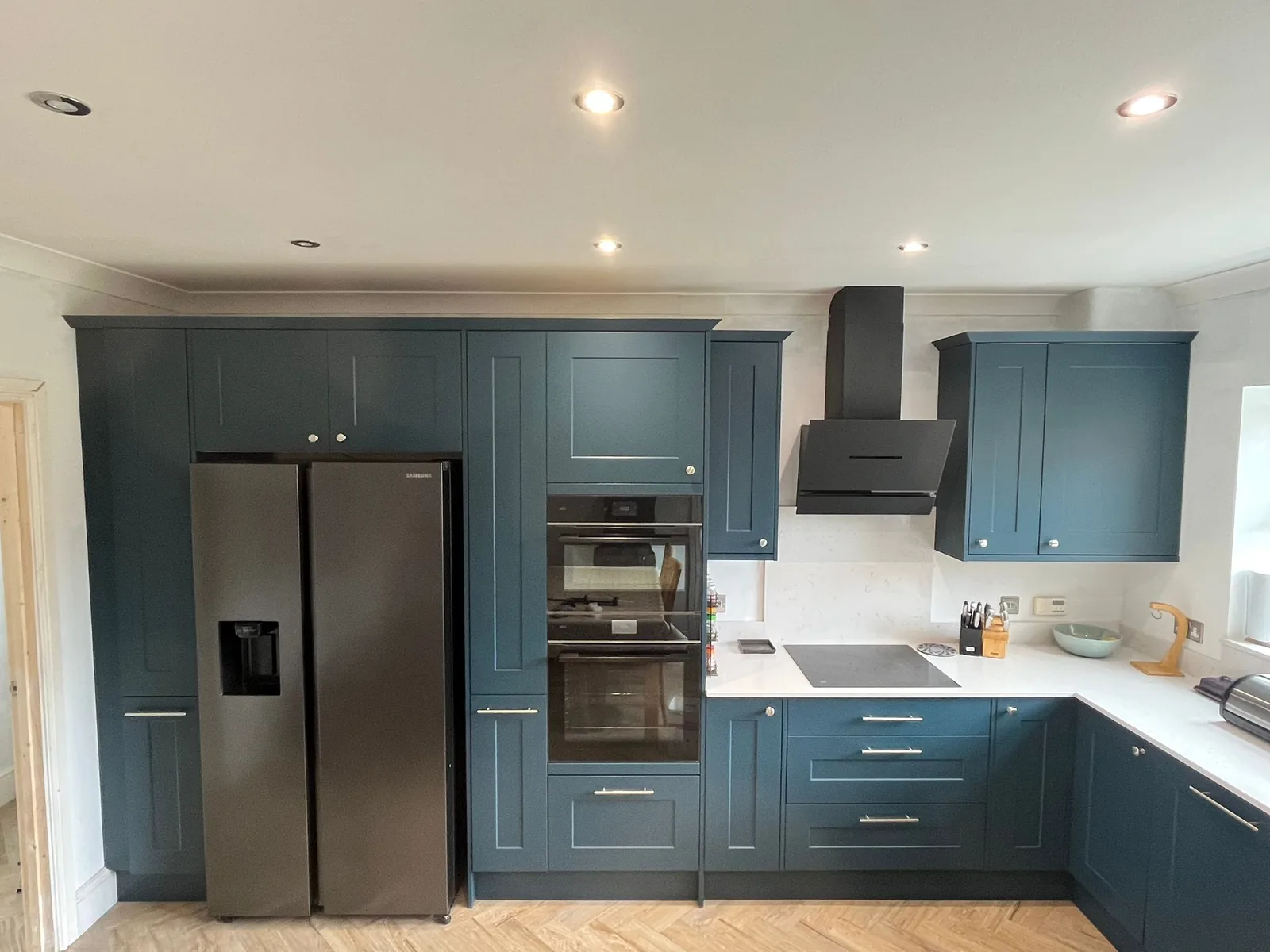 Navy kitchen with American fridge freezer, built in ovens and induction hob fitted